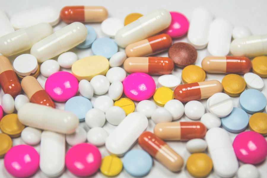 An assortment of loose pills and capsules on a white surface